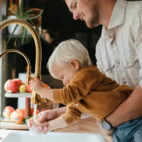 Father and baby at sink